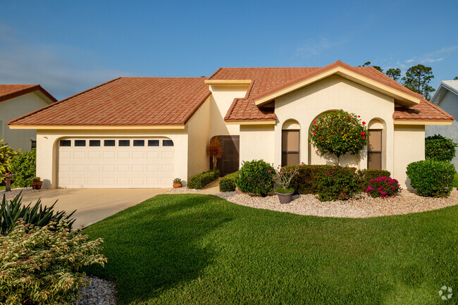 Single-story ranch home with Mediterranean style barrel tile roof. and manicured landscaping