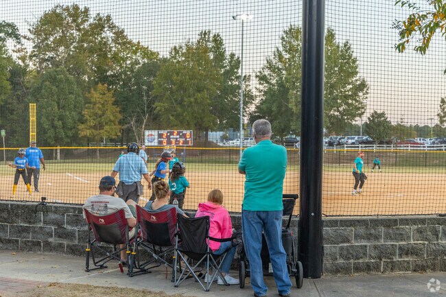 Parkwood parents watch on as their kids play ball on one of the lighted fields at Freedom Park.