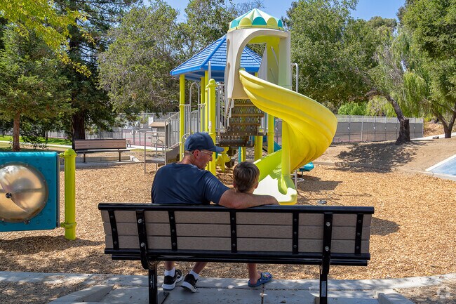 A grandfather shares a conversation with his grandson on a bench at Sinsheimer Park.
