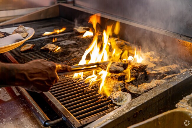 Sizzling chargrilled oysters at Acme Oyster House in Whitney-Cecile deliver bold flavors and a true taste of Louisiana tradition.