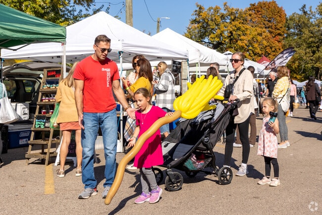 Merrill Algonquin Hills families stroll the holiday market with balloon broom prizes.