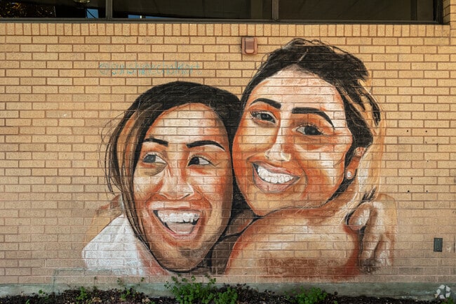 Salt Lake County Library West Valley Branch in Granger has a vibrant mural of two woman smiling.