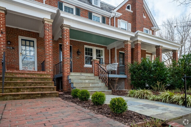 A brick porch with a swinging bench offers residents of Glover Park to relax with a book.