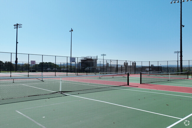 A close up of the game set and match tennis courts at Wilbur H Lynch Literacy Academy.