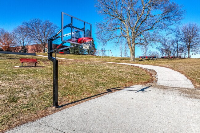 An outdoor basketball court hosts recess games of HORSE.