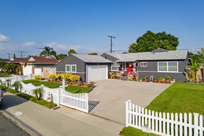 Home with picket fence and wide driveway are among many midcentury build homes.