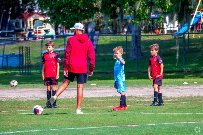 Children attending soccer practice in University enjoy the green space at Jay Blanchard Park.