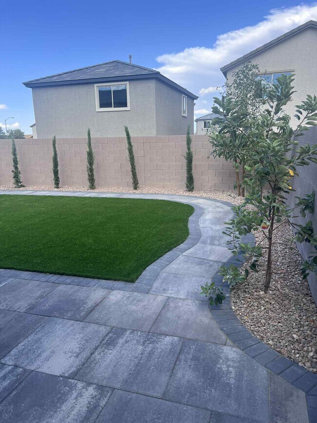 land scaped backyard with walk around paver path
