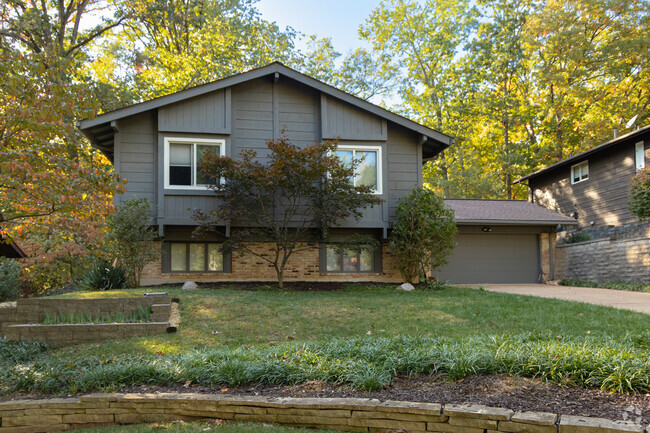 Split level home in Twin Oaks surrounded by tall trees.