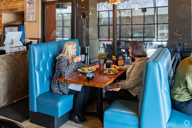 Two friends catch up while dining at the New Vintage Grill near Emerald Estates.