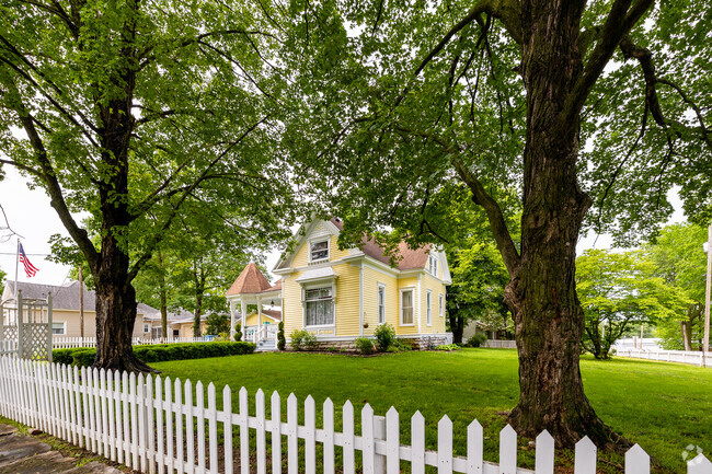 A white picket fence surrounds a traditional Queen Ann home in Ozark.