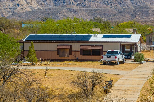 This modern manufactured home blends into the hilly desert landscape, with a long driveway and views of the nearby peaks in Elephant Head.