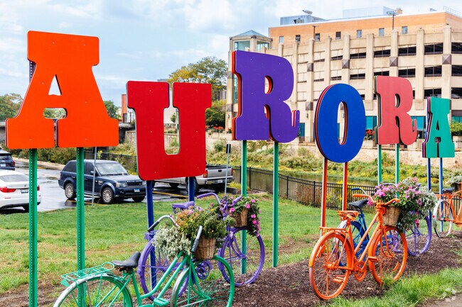 Downtown Aurora welcome city sign with colorful bikes placed in front of it.