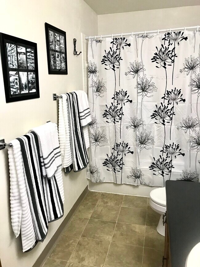 Bathroom with full tub, recent remodel, tile floor, updated countertop and sink, fresh design.