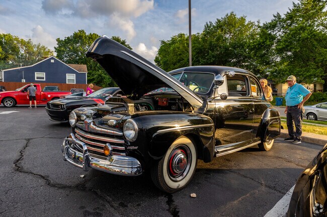 Bystanders look over a classic car on Kearney Street just outside the Doling Park neighborhood.