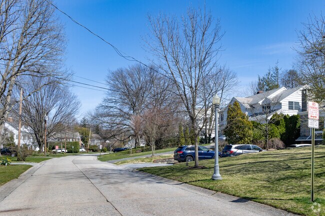The streets of Plandome Manor are tree lined with manicured lawns.