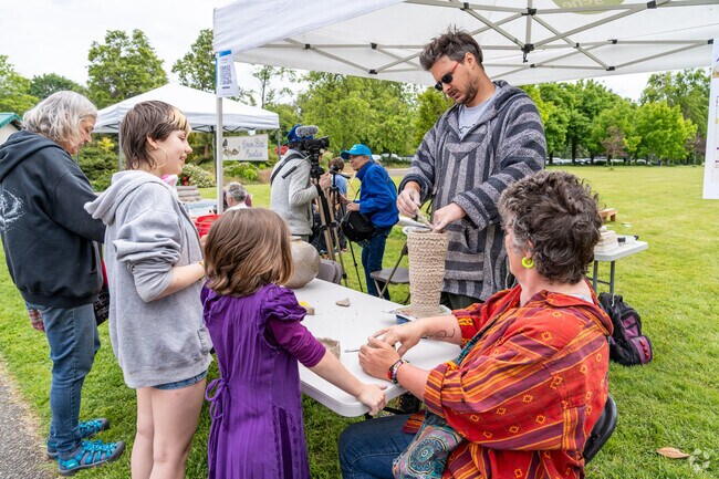Visitors watch an artist at Art-4-All in the Park in Harlow.
