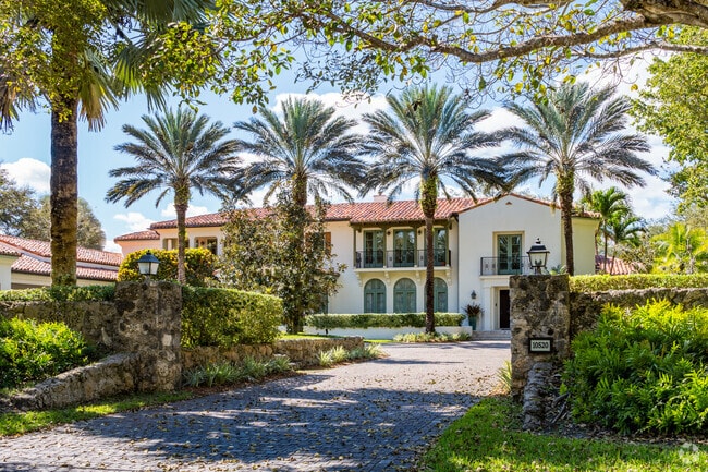 Spanish-style home with a row of palm trees in the driveway are prominent in Snapper.