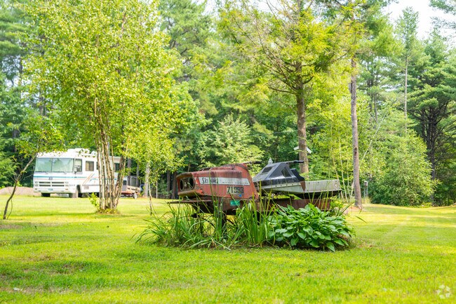 A stack of old school snowmobiles really compliments this lawn in Loudon.