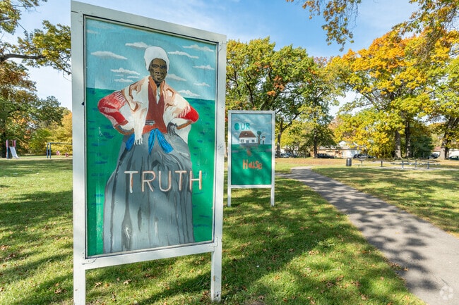 Visitors enjoy playtime along shaded paths at Krainz Park, which is filled with colorful art.