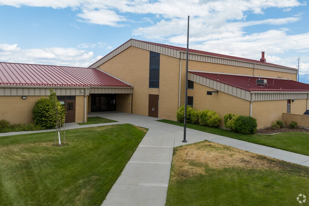 A red metal roof contrasts the yellowy beige building at Hillside Elementary School.