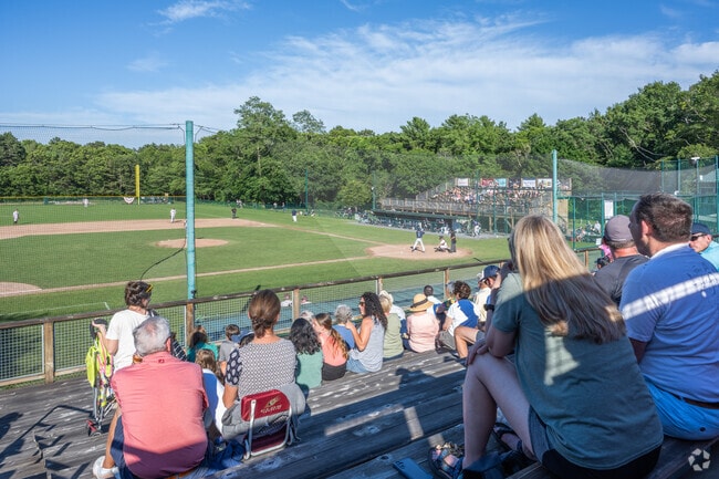 Residents cheer on the Cotuit Kettleers at Lowell Park on warm summer nights.