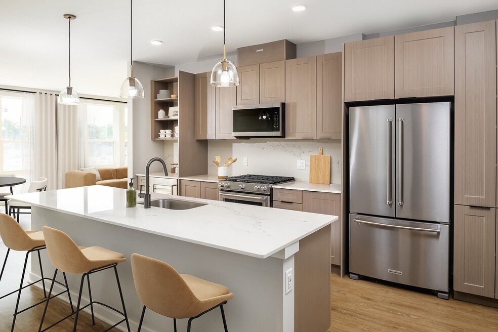 Signature Collection Kitchen with oak shaker cabinetry, marbled white quartz countertop, and upgraded stainless steel appliances