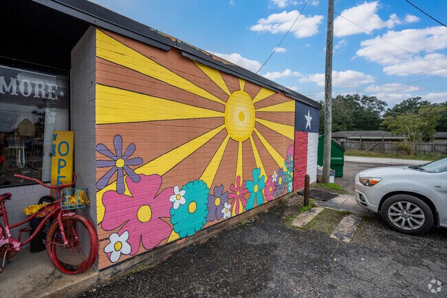 A colorful mural adorns the side of a building in central Winnie, Texas.