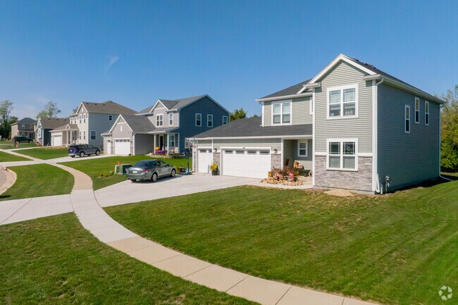 A two-story home anchors a peaceful block with broad driveways and lawns.