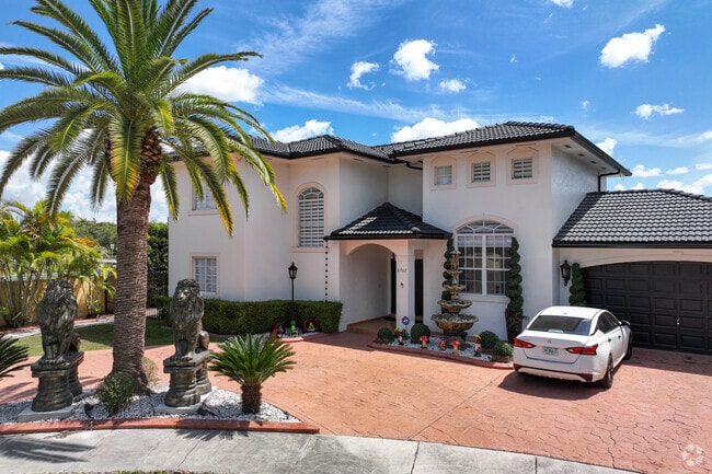 Palm trees add minimal shade to the front yards of Spanish-style homes in Miami Lakes.