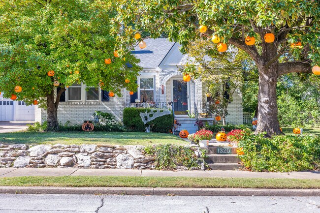 A charming home delights with jack-o'-lanterns hanging from trees in Rennaisance.