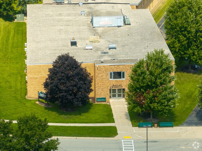 Entrance to Eastview Elementary School with benches and trees in Lake Geneva, Wisconsin.