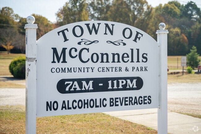 A white and black sign for the Town of McConnells.