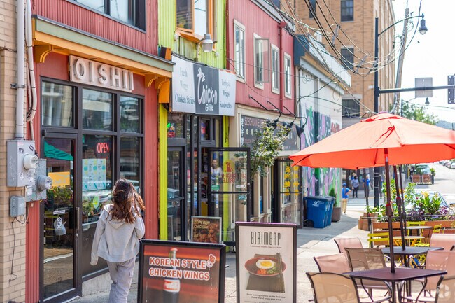 Restaurants line the busy streets of Oakland with outdoor dining areas on the sidewalks.