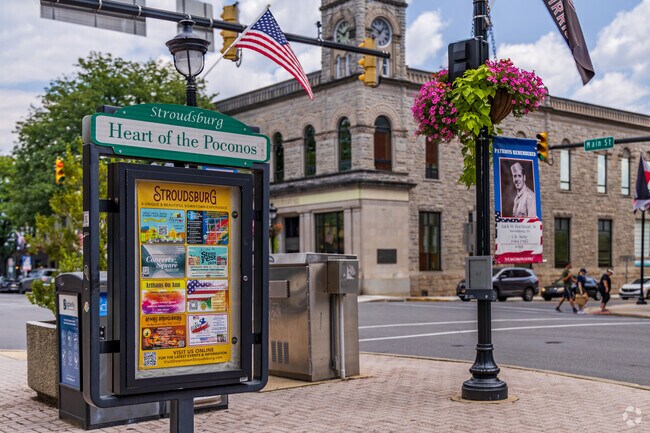 A town sign features local experiences and events at the entrance of downtown East Stroudsburg.