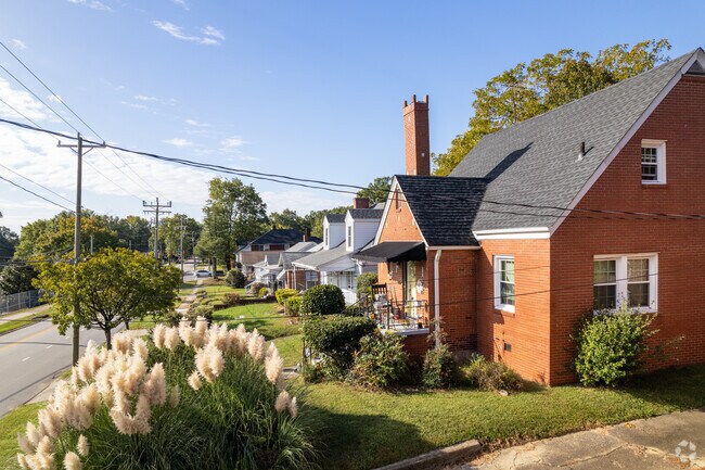 A row of cape-cod and bungalow homes with small front yards and beautiful landscaping.