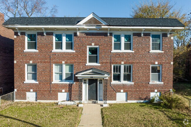 This colonial style home features a brick facade and symmetrical design.