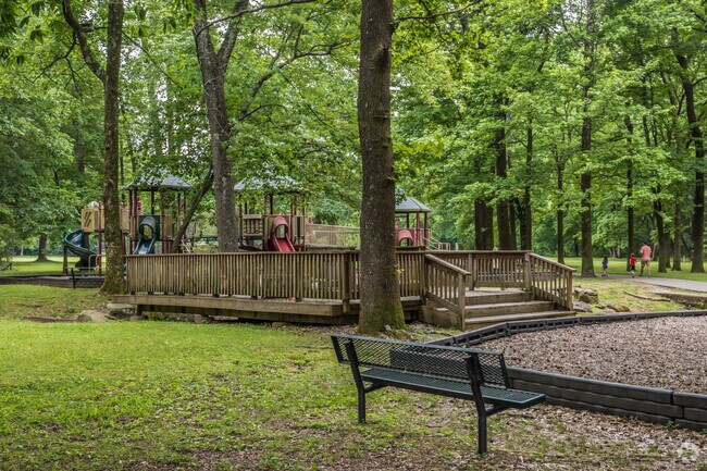 Kids can play in the shade on the playground at Poplar Estates Park in Germantown.