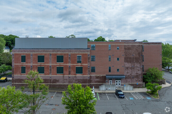 There's a parking lot on the left side of the Missituk Elementary School building.