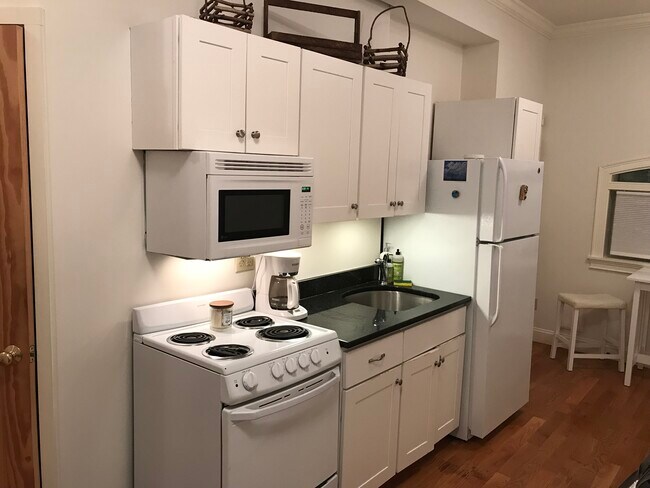 Full kitchen with stove and microwave and full size refrigerator