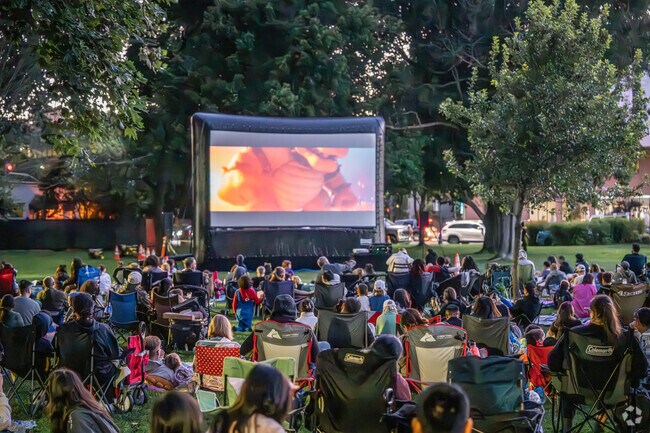 Families settle in with excitement as the movie begins, enjoying the brisk evening.