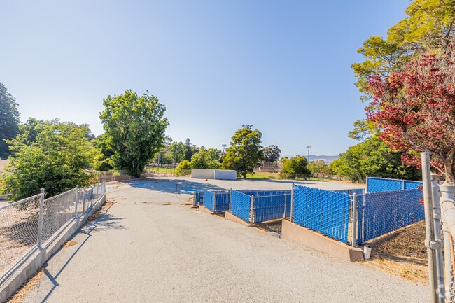 El Crystal Elementary School has a paved play area and fenced garden space behind the campus.