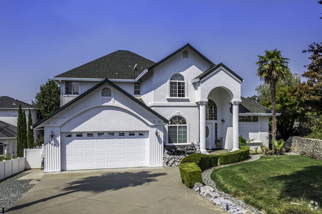 This modern custom two-story home has an archway entrance in Bluffs.