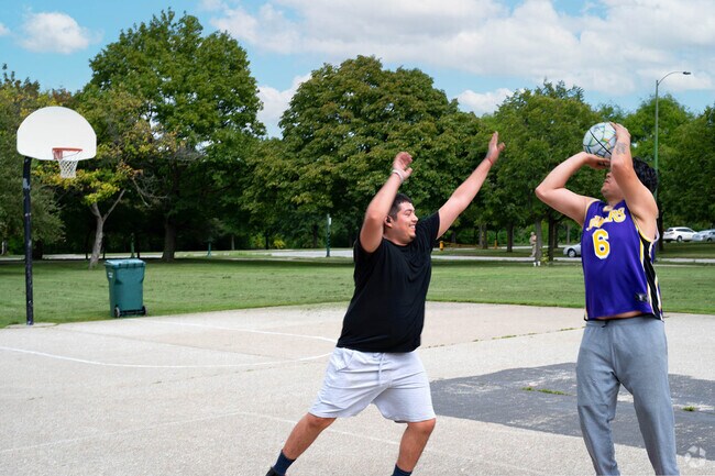 People  enjoy a game of basketball at one of Marquette Park’s outdoor courts, a hub for fitness and fun in Chicago Lawn.
