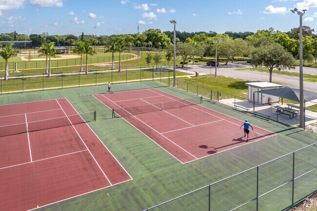 People playing tennis in Bonita Springs Community Park, located close by to Arbel.