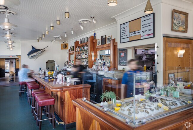 Friends relax at the bar at Little Dom's Seafood near Old Town Carpinteria.