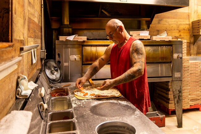 A pizza cook puts together a pie for a takeout order from Leo's Pizza near Oakhurst.