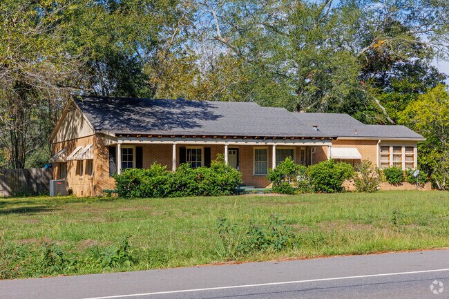 Impressive brick ranch home with long covered front porch.