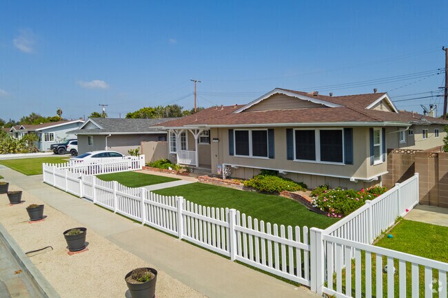 Ranch-style homes in Harbor Gateway feature picket fences and vibrant landscaping.