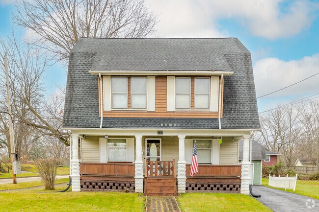 Colonial Farmhouse home with a tidy lawn in Central City neighborhood.